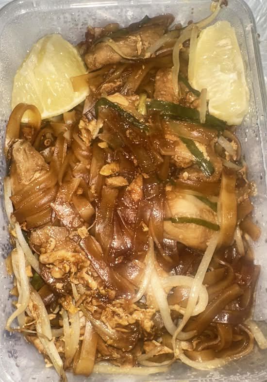 Pad Thai with chicken, bean sprouts and lemon, in a takeaway box