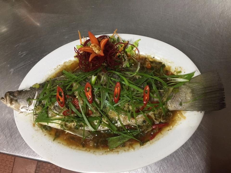 A whole steamed fish under spring onion, ginger and chilli